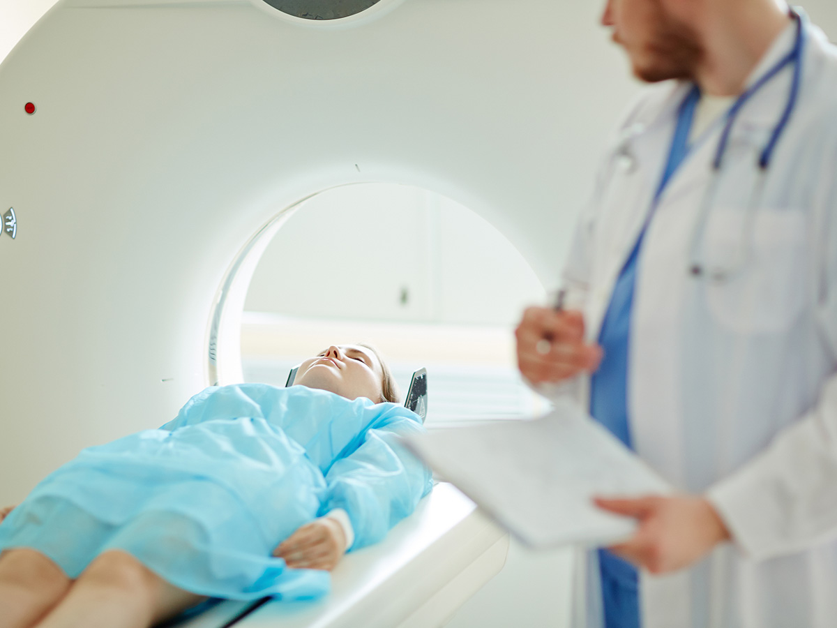 Doctor examining a female patient with CT scanner.