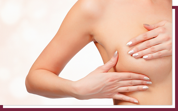 Woman checks her breast implant for signs of leaks or problems.