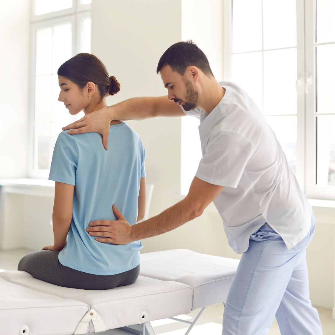 A man putting his hands on a woman's spine.