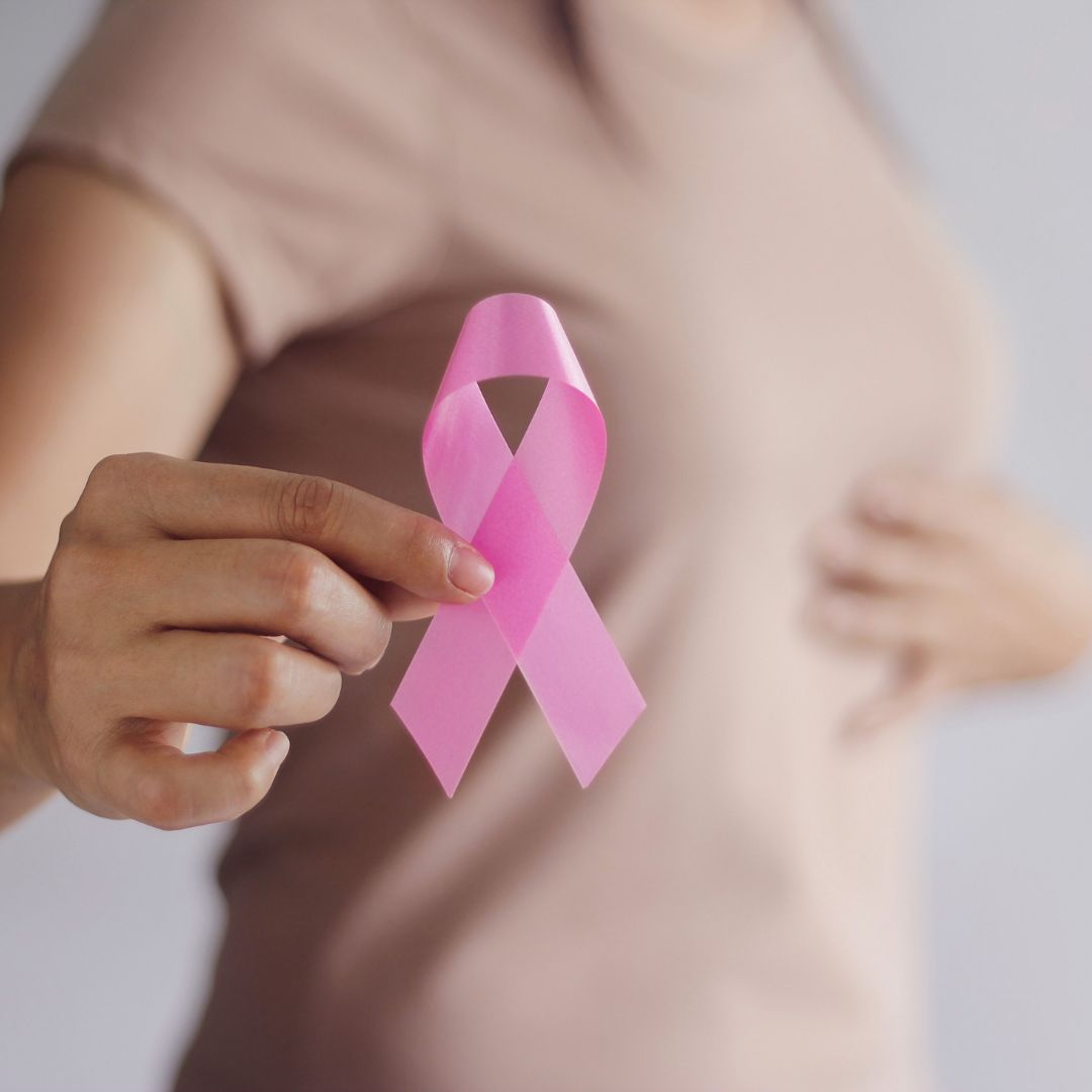 A woman holding a Breast Cancer ribbon.