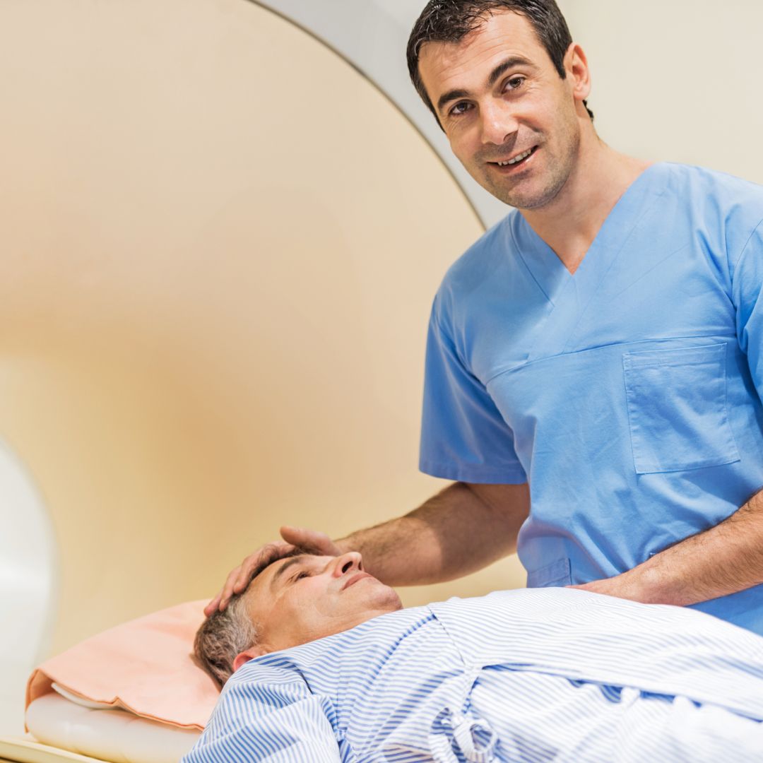 A male radiologist with a patient and an MRI machine.