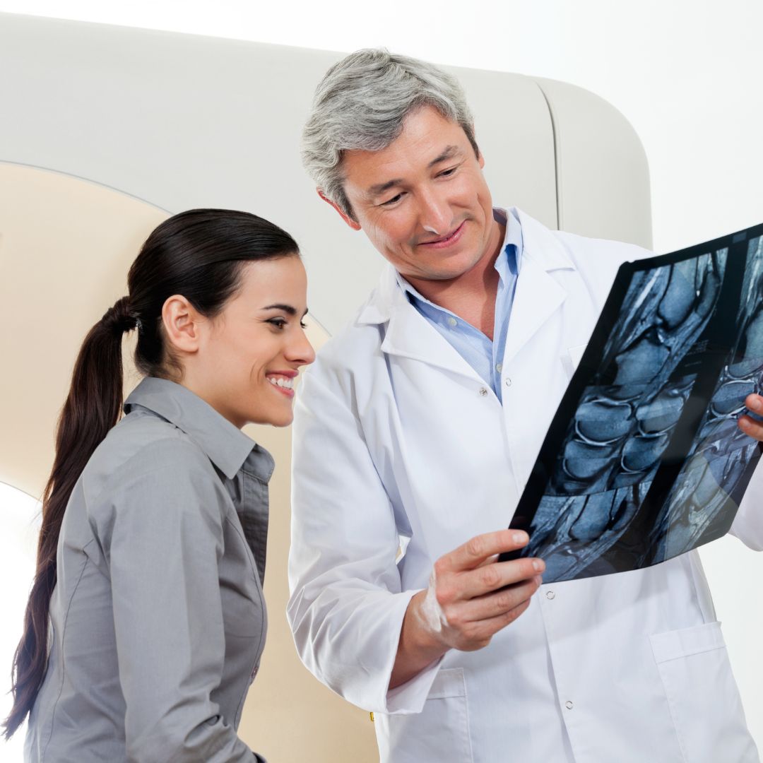 A male radiologist looking at scans with a patient.